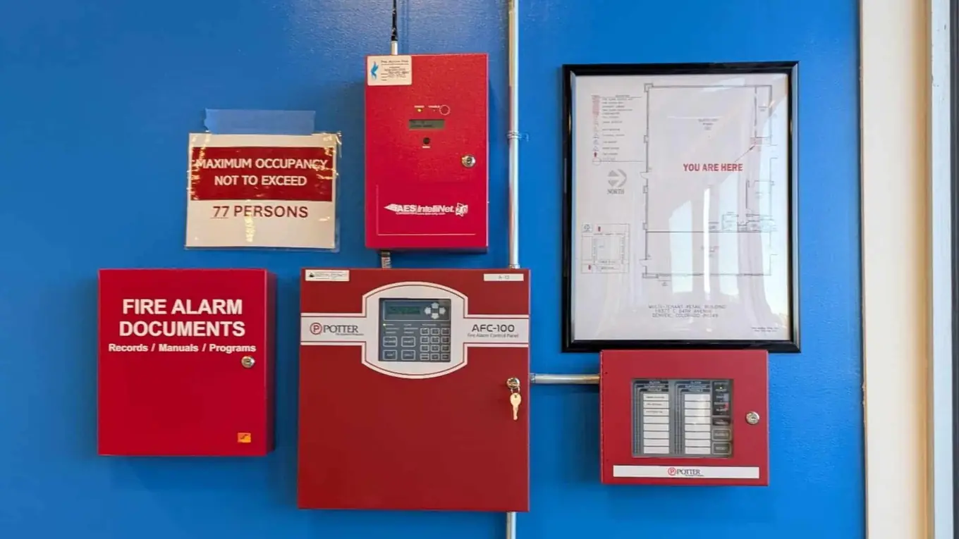 Fire alarm control panel, annunciator and fire alarm document box on a blue wall
