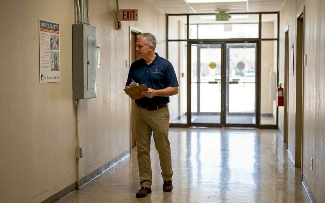 Manager checks fire safety during building inspection